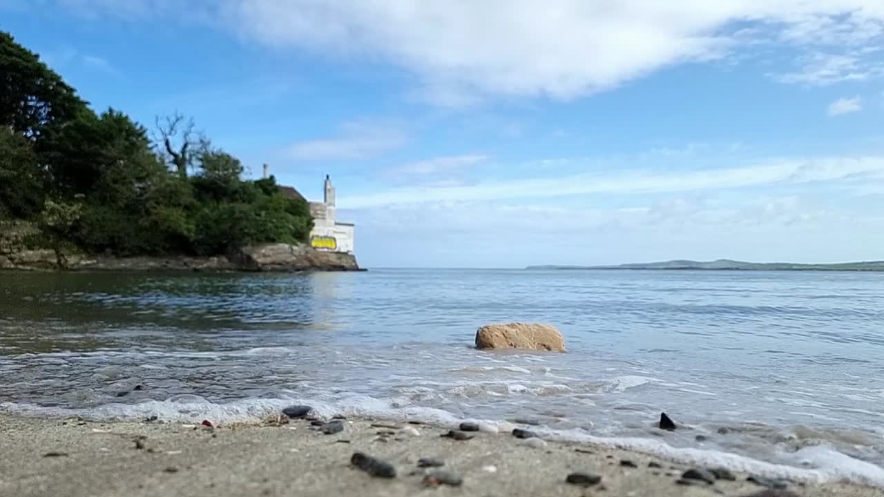Gorsedd Y Penrhyn hidden Welsh beach with slow motion turquoise waves crash over coastal rock