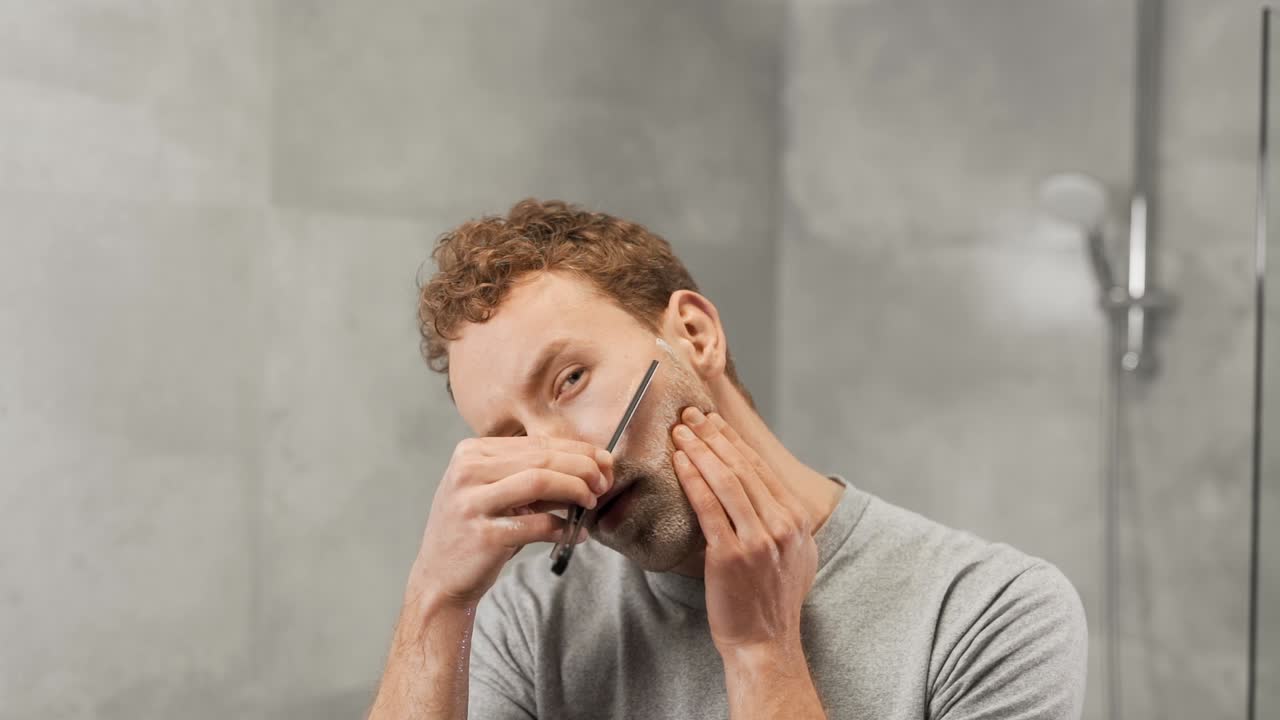 위험한 면도칼로 면도하는 남자