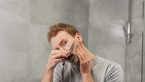 a man shaves with a dangerous razor