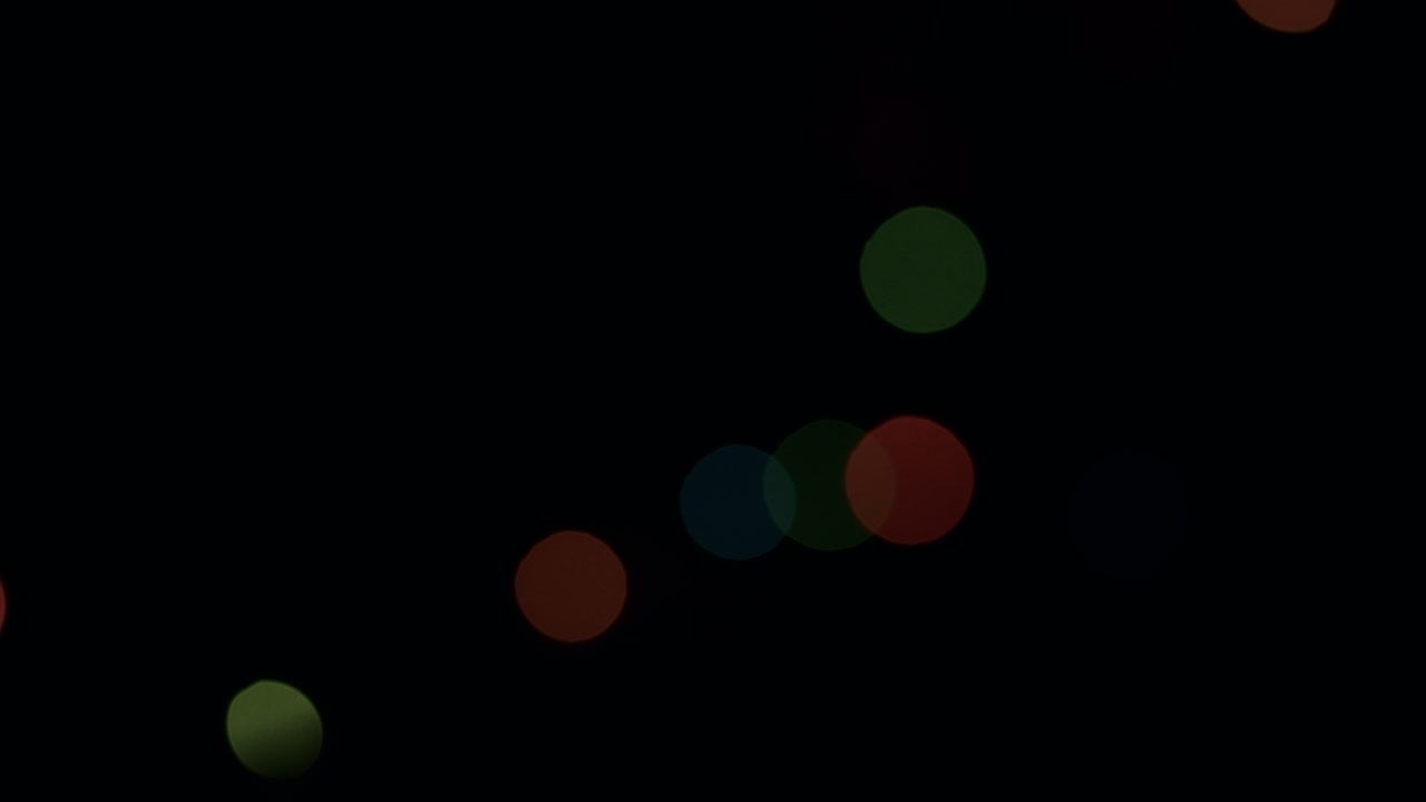 흑색 배경에 오렌지색, 빨간색, 초록색 보케 조명을 박이는 왼쪽에서 오른쪽