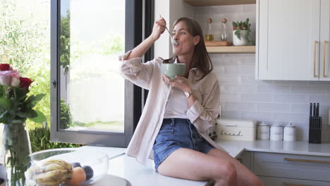 middle-aged caucasian woman enjoys a meal at home, with copy space