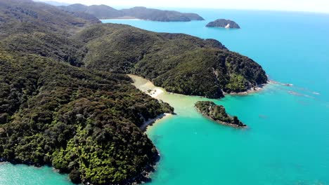 Luftaufnahme-Von-Bewaldeten-Hügeln-Im-Kontrast-Zum-Ruhigen-Blauen-Wasser-Und-Den-Weißen-Sandstränden-Im-Able-Tasman-Nationalpark