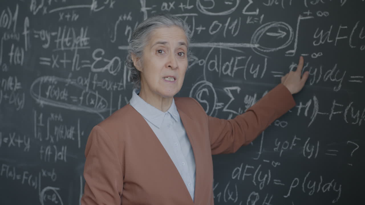 Teacher Explaining Math on a Chalkboard