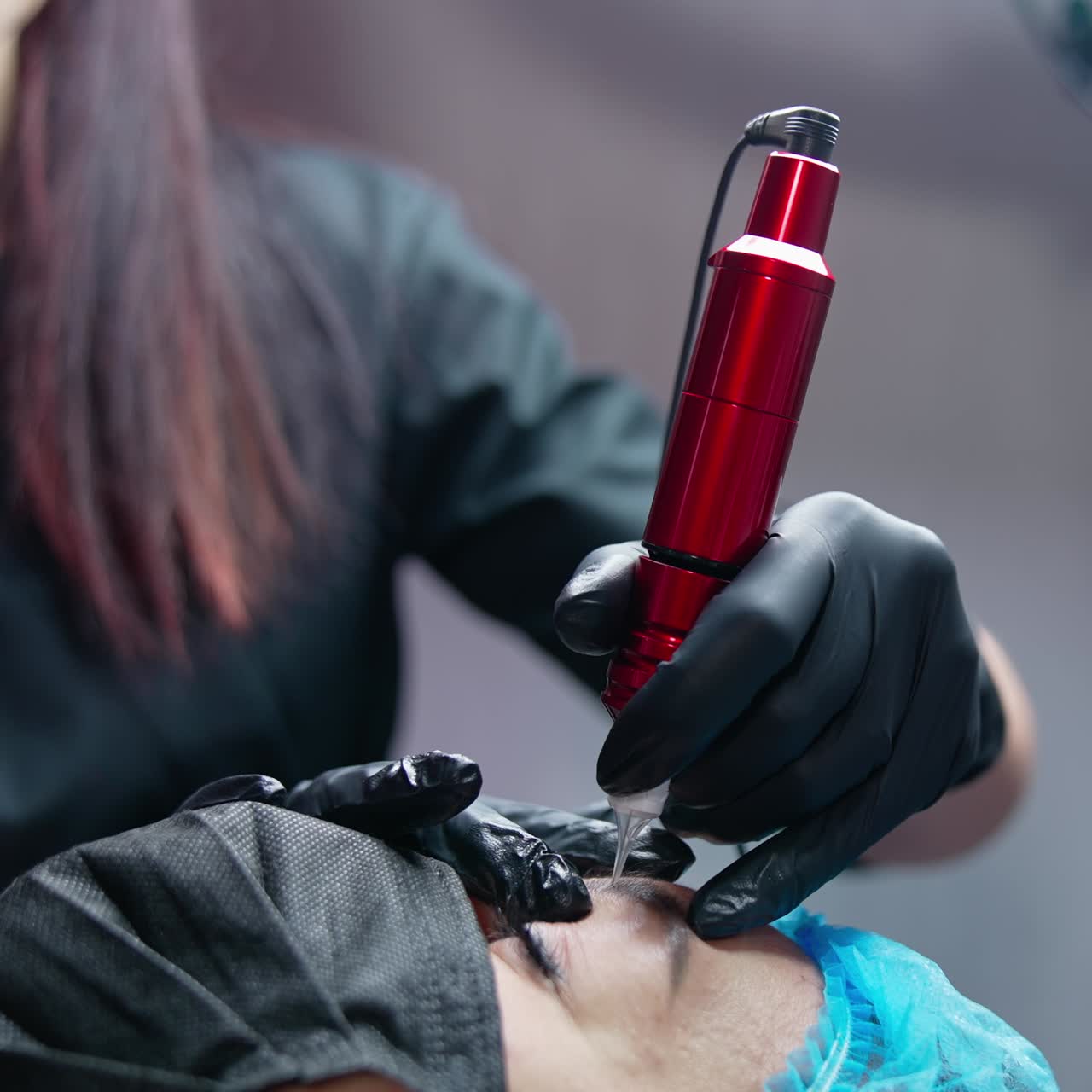 Cosmetologist work with machine. Cosmetologist using eyebrow tattoo machine