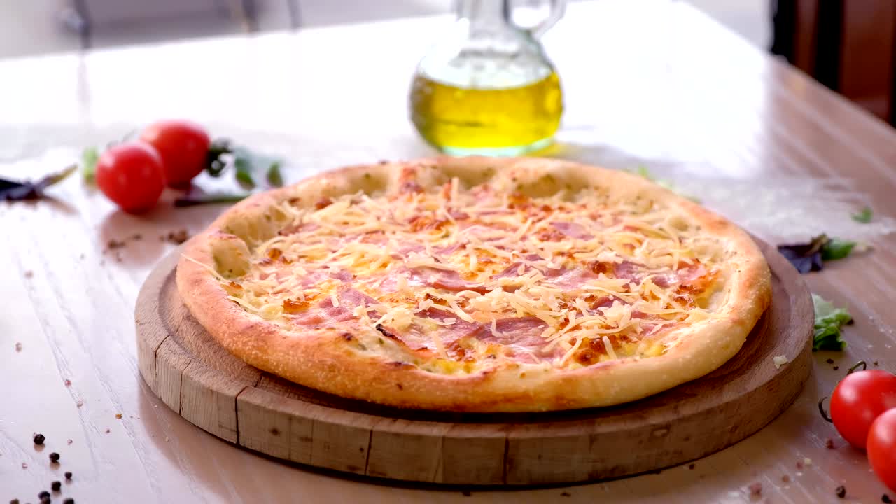 Chef cosparge formaggio grattugiato su pizza con pancetta. Mani con guanti di gomma