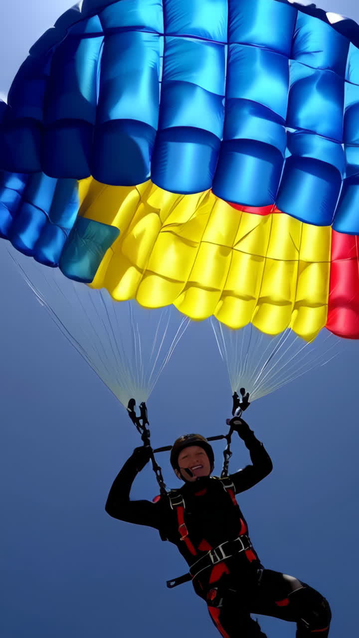 Skydiver with colorful parachute against a blue sky