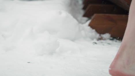 Woman's-feet-come-out-of-the-frozen-water-and-enter-the-sauna.