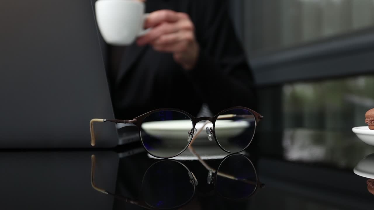 mujer trabajando en una computadora portátil con café y vasos