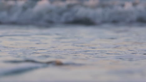 olas del mar corriendo en la playa durante la puesta de sol