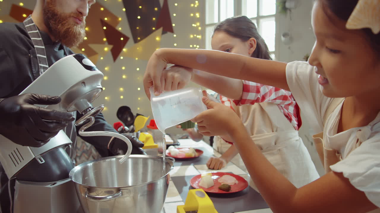 niños añadiendo ingredientes al tazón de mezclador en la clase maestra culinaria