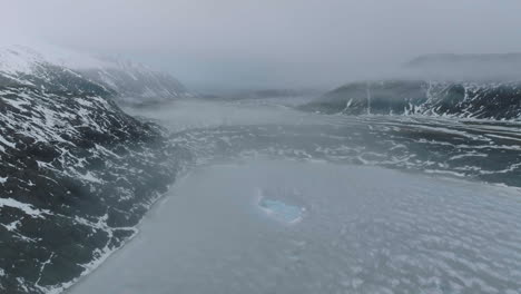 paisaje helado de islandia en la temporada de invierno, vista aérea de un lago glacial, icebergs y colinas volcánicas cubiertas de nieve