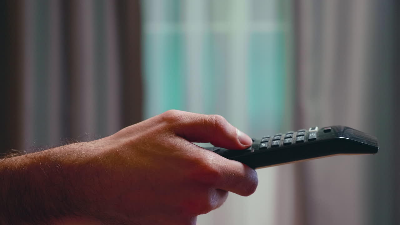 Close up of businessman using tv remote control