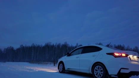 white car on snowy road at night