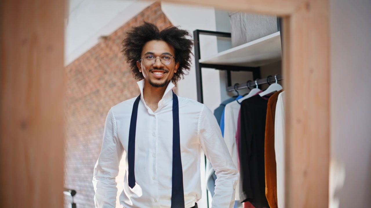 Smiling shopper walking clothing store fitting room. Man untied tie white shirt.
