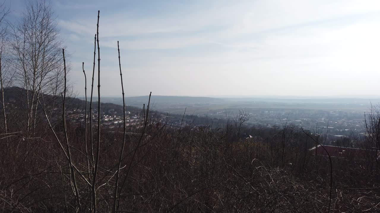 A panoramic view from the Malzéville Plateau, showcasing the sprawling landscape below with distant towns and rolling hills under a clear sky.