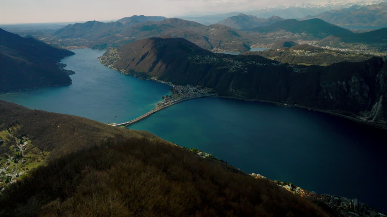 vista panorámica de las enormes aguas turquesas del lago como rodeado por el idílico terreno montañoso de los alpes