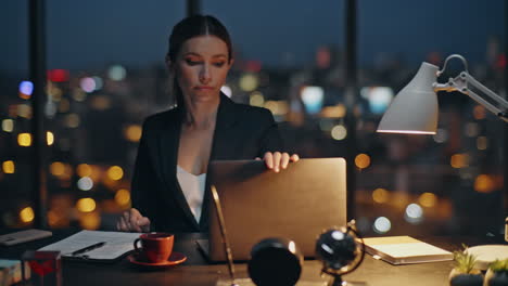late executive finishing work closing laptop at night cityscape. nervous lady