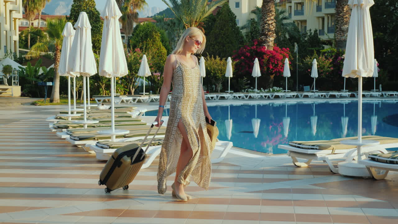 una mujer con una bolsa de viaje se instala en el hotel-resort para pasar unas vacaciones junto a la piscina