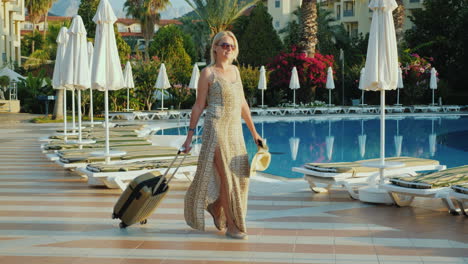 a woman with a travel bag is settled in the hotel-resort for a vacation passing by the pool