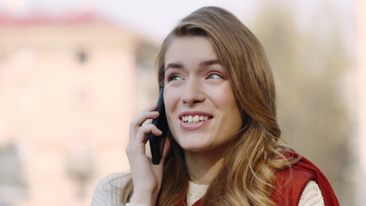 Emotional woman talking mobile phone outdoors. Excited girl calling cellphone