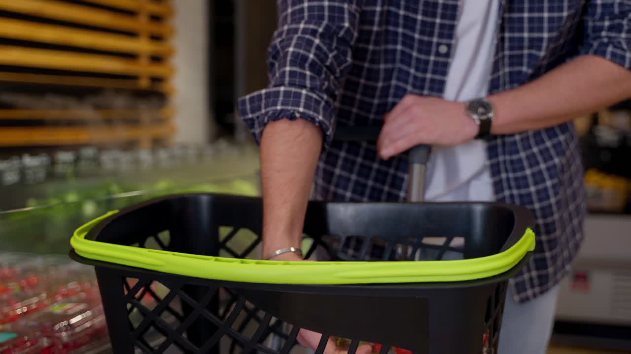 persona que compra fresas en una tienda de comestibles