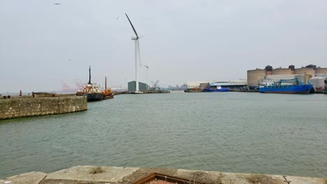 dockland waterfront with wind generator and old ship docked in port