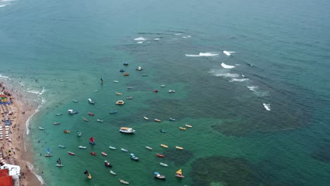 Absteigende-Luftdrohne-Weitwinkelaufnahme-Des-Hafens-Von-Porto-De-Galinhas-Oder-Hühnerhafen-Mit-Verankerten-Segelbooten-Und-Touristen,-Die-Im-Kristallklaren-Meerwasser-In-Pernambuco,-Brasilien,-Schwimmen