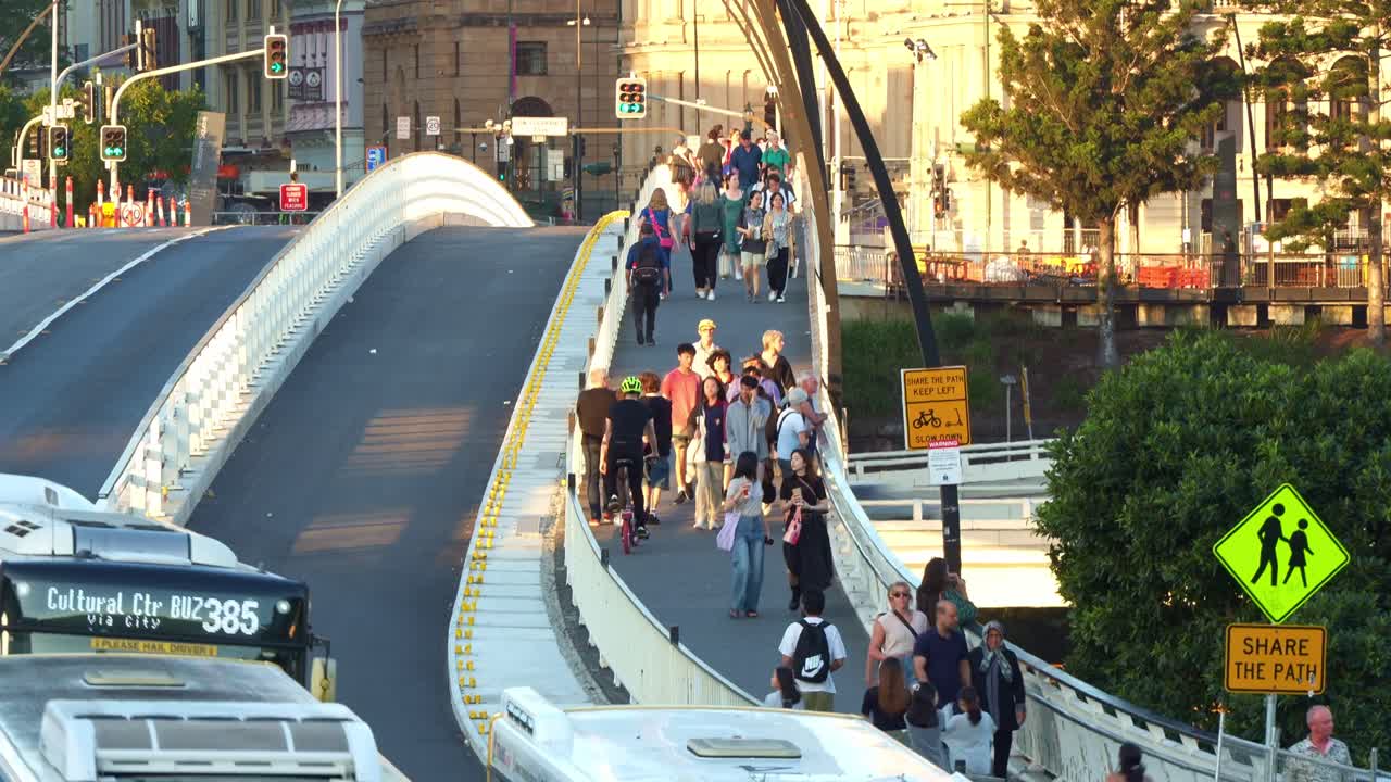Busy South East Busway, buses on Victoria bridge and pedestrians on the walkway, Brisbane's vibrant street scene views from Cultural Centre station captured in fast motion time-lapse shot.