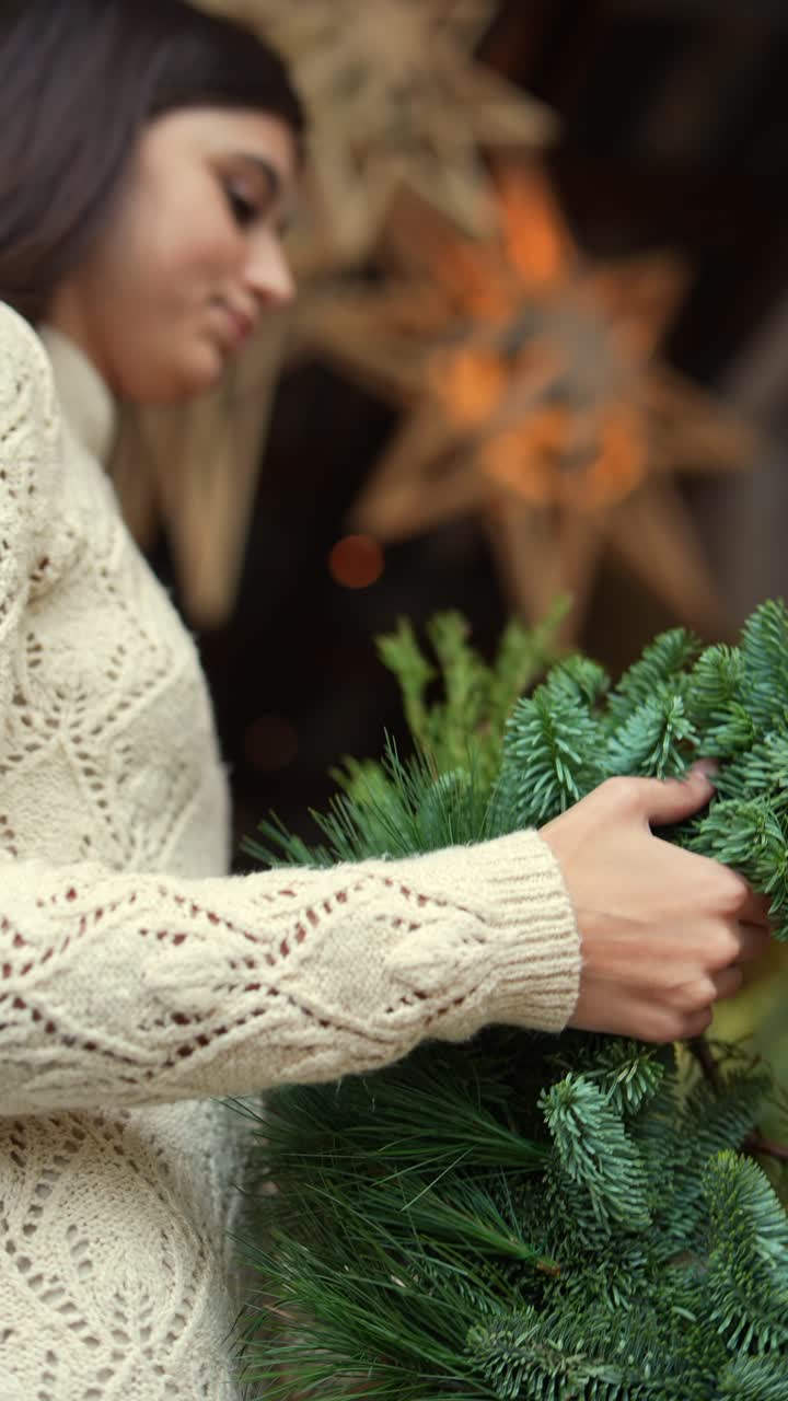 mujer decorando una corona de navidad