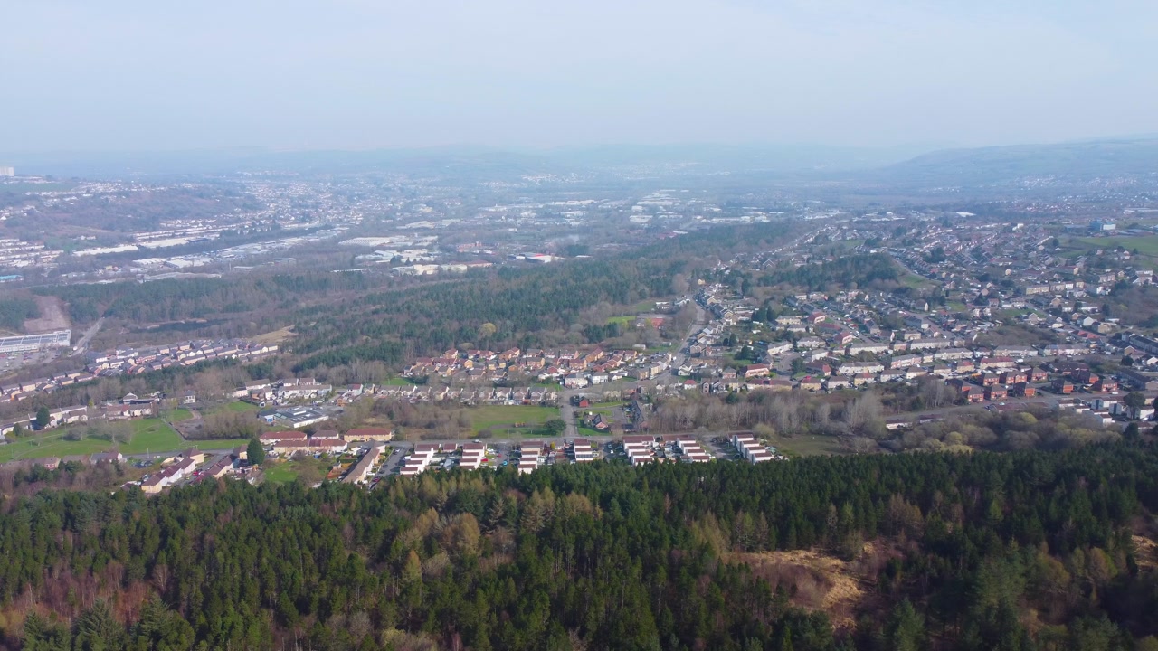 Aerial View Over Swansea East with Landscape of Houses and Buildings and Forest Trees in Foreground.