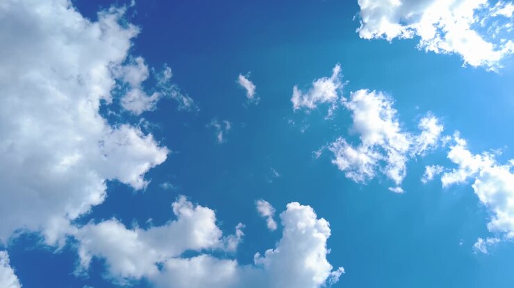 Timelapse van wolken en een blauwe zonnige hemel. Een lus van witte wolken boven een blauwe lucht met zonnestralen. Luchtopname (drone) van bewegende wolken; een natuurlijke blauwe lucht met helder weer.