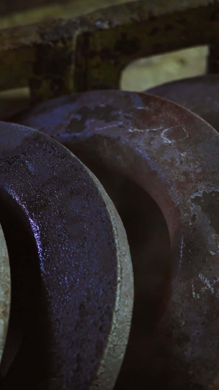 discos metálicos apilados con óxido y pátina que se enfrían con vapor visible en la fundición