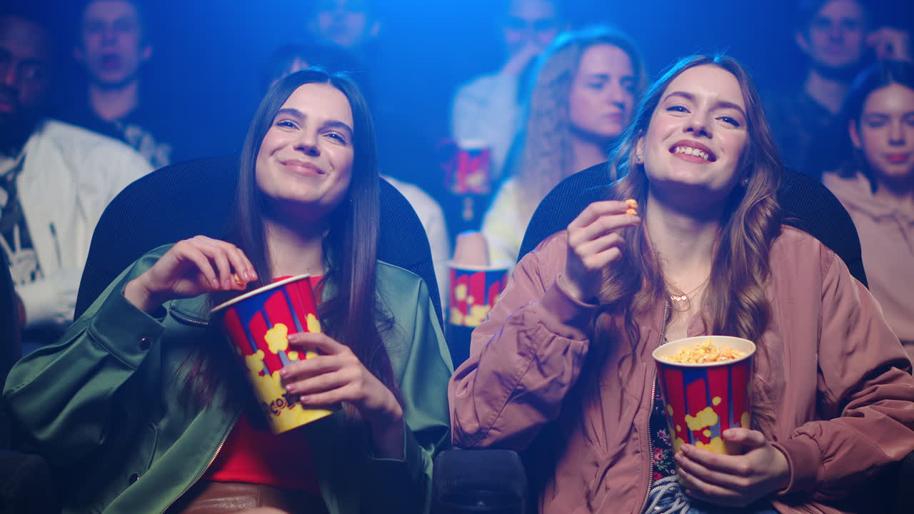 mujeres alegres divirtiéndose en el cine