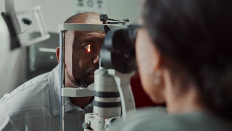 un hombre tiene sus ojos revisados por un oftalmólogo.