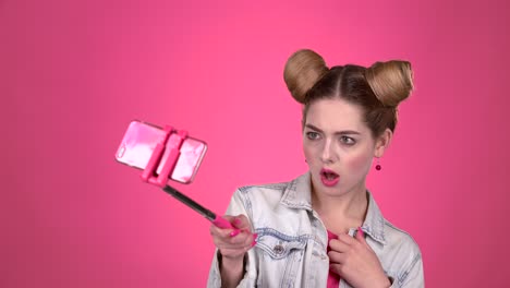 young woman taking selfie with pink selfie stick