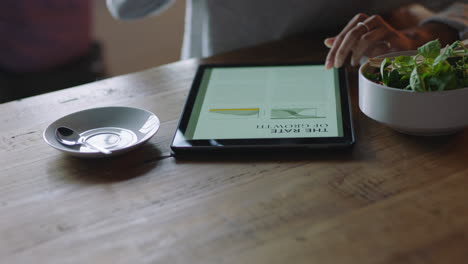 close up business woman hands using digital tablet computer in cafe drinking coffee reading email document on mobile touchscreen device enjoying portable technology busy restaurant