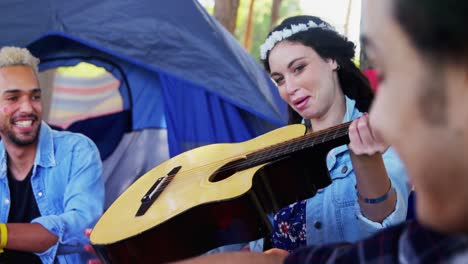 mujer pasando la guitarra a sus amigos en el festival de música 4k