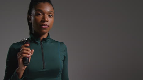 Studio-Portrait-Of-Female-Athlete-Wearing-Tracksuit-Training-In-Gym-Fitness-Class-With-Jump-Rope-Or-Skipping-Rope-Against-Plain-Background-2