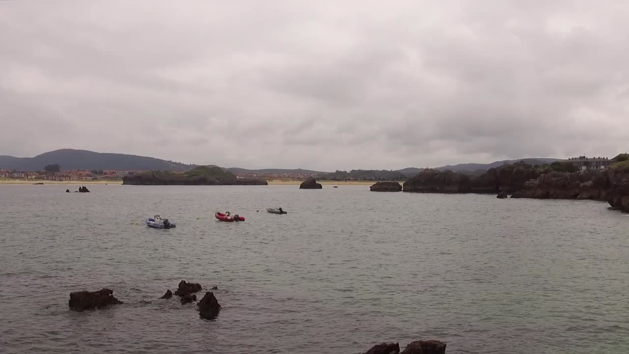 Calm sea view with boats near Playa de Quejo, featuring distant San Pedro Islet