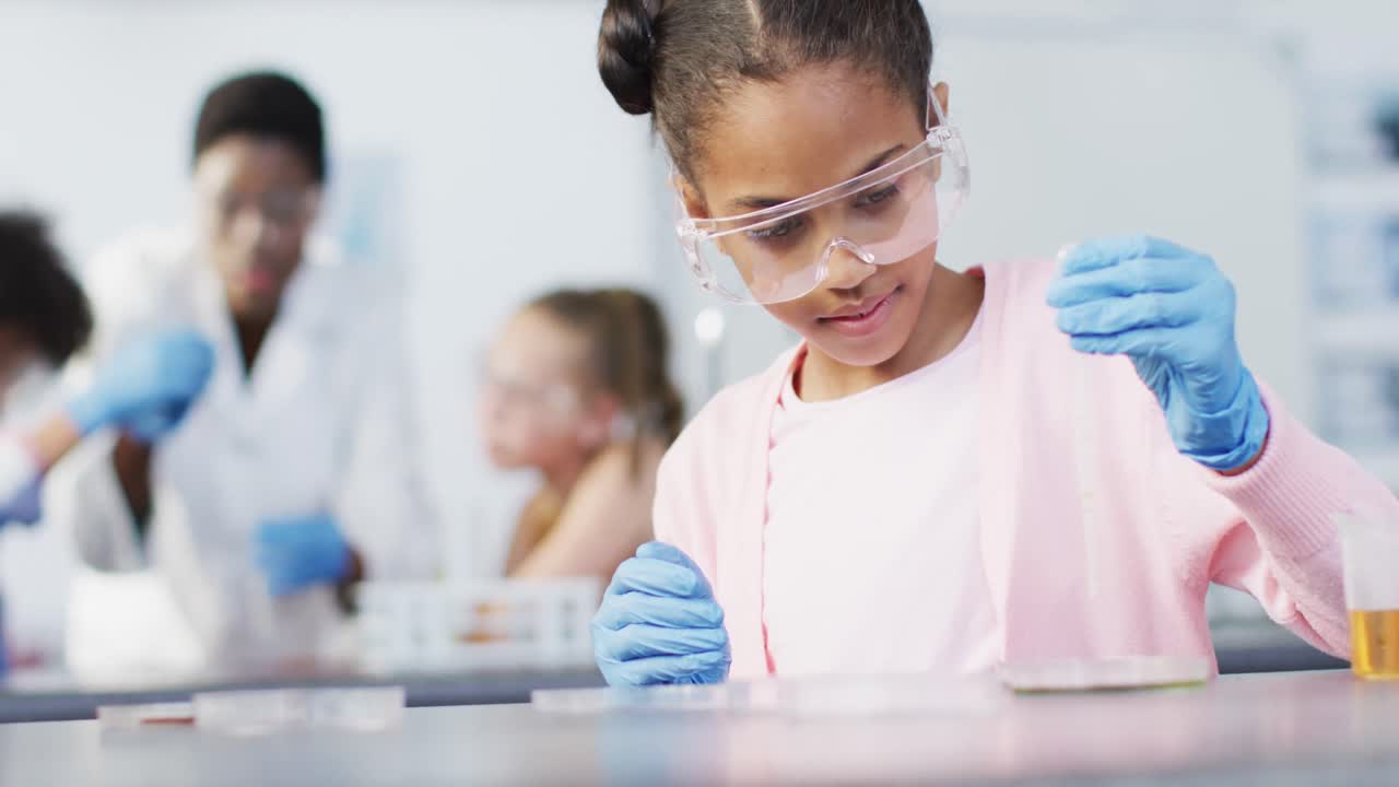 maestra diversa y escolares felices teniendo clase de ciencias en el laboratorio escolar