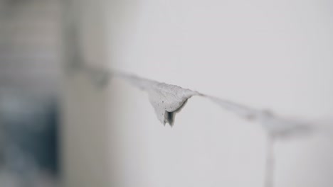 plasterer smears excess glue on white gypsum pasteboard