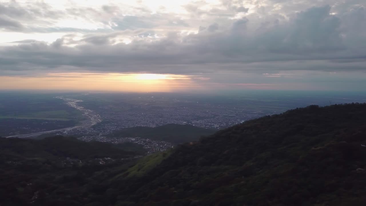 Take aerial with drone, city in Colombia dawning, great mountains with a colorful sky, orange sun.