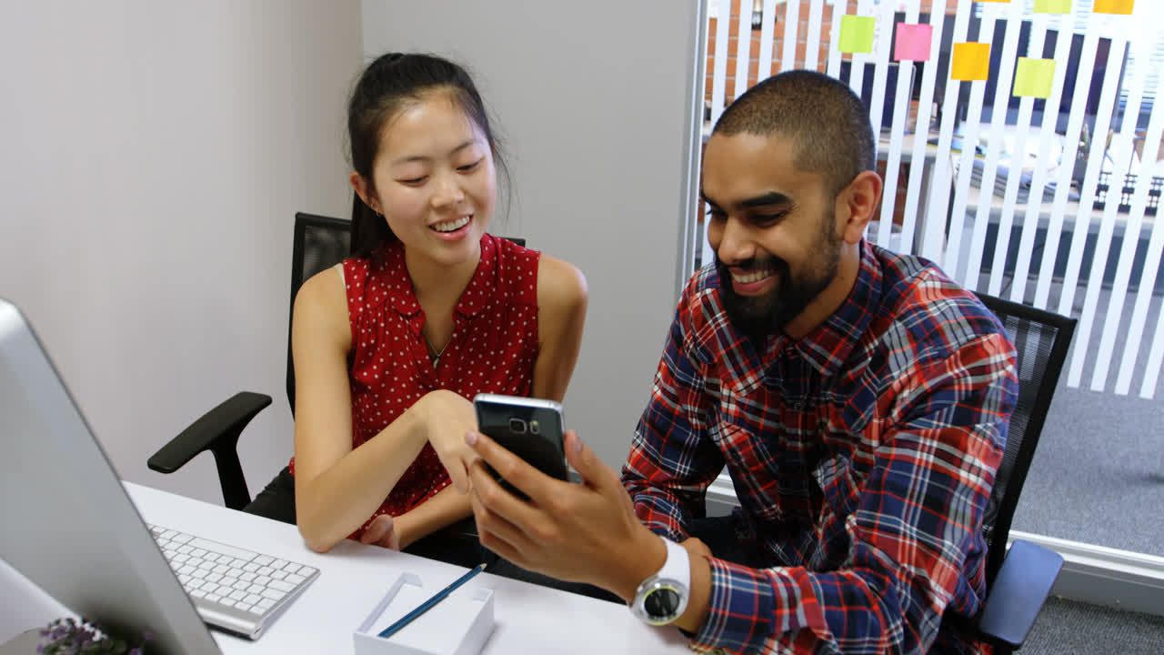Business executives discussing over a mobile phone 4k