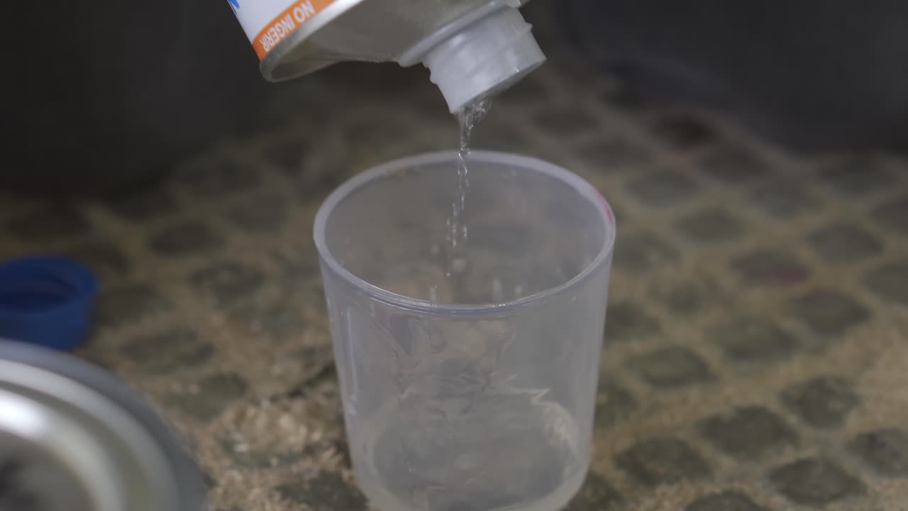 verter tinte de madera en un pequeño cubo de plástico