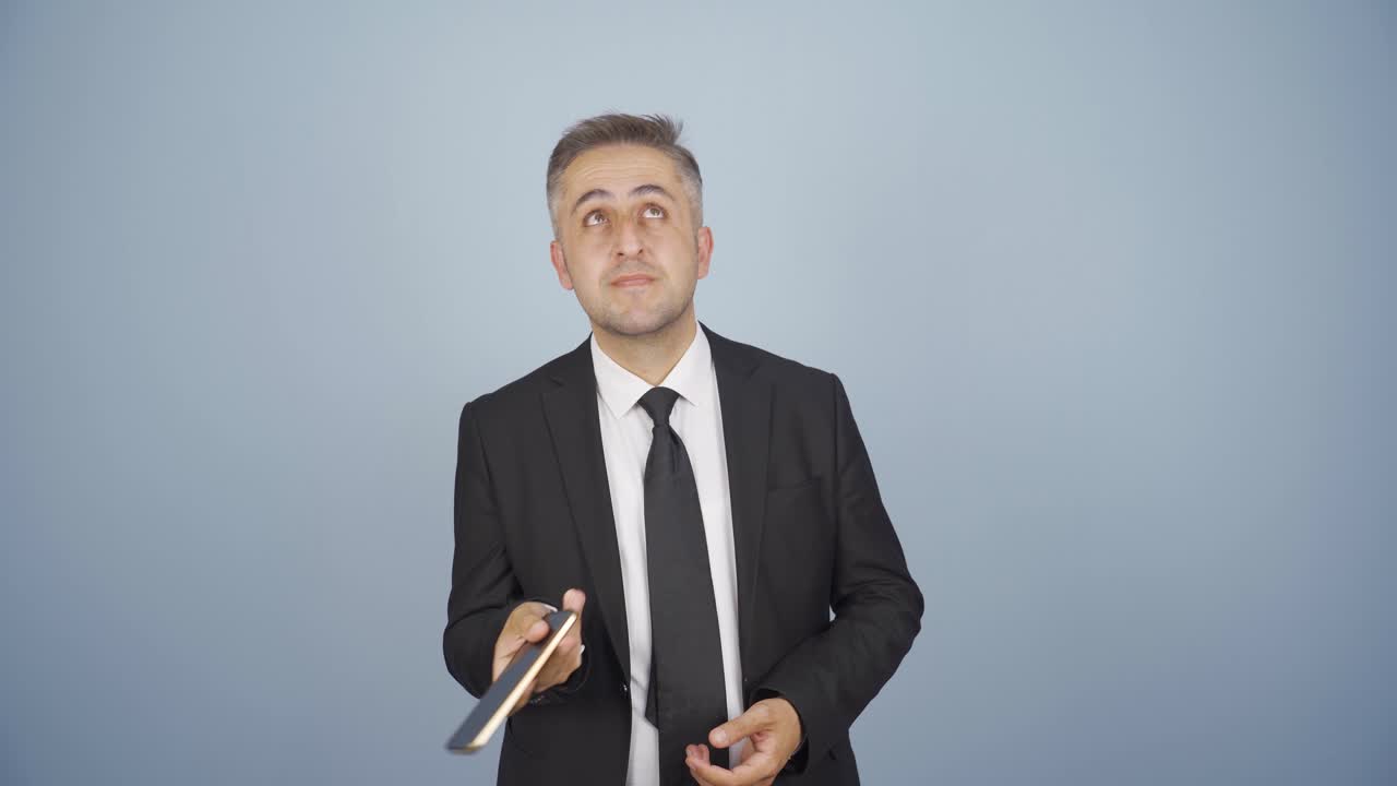 스트레스를 받은 사업가, 손에  ⁇ 드폰, अनिश्चित한 표정.