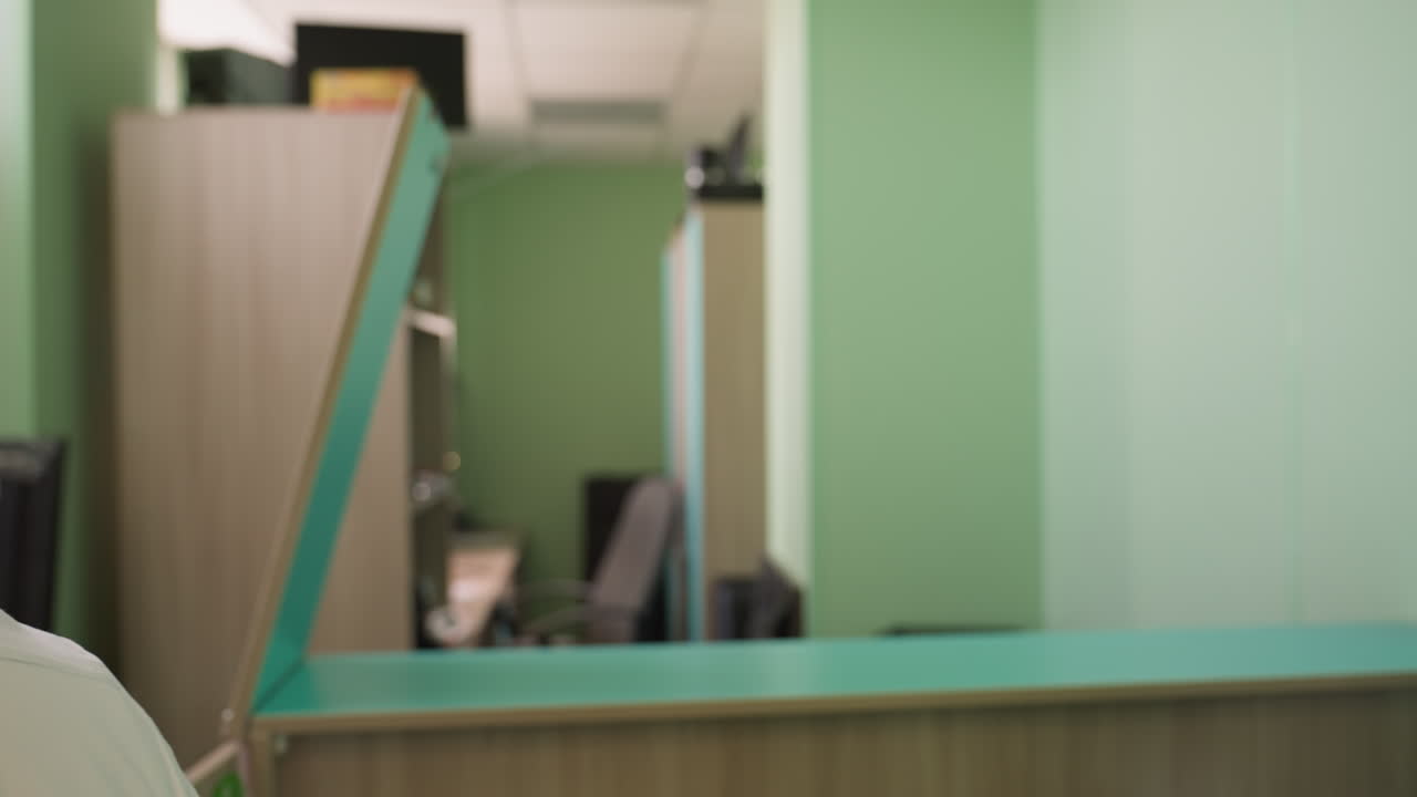 una vista trasera de un hombre que se pone su bata de laboratorio en un entorno profesional, el hombre se ve desde atrás, ajustando el cuello de su bata de laboratorio