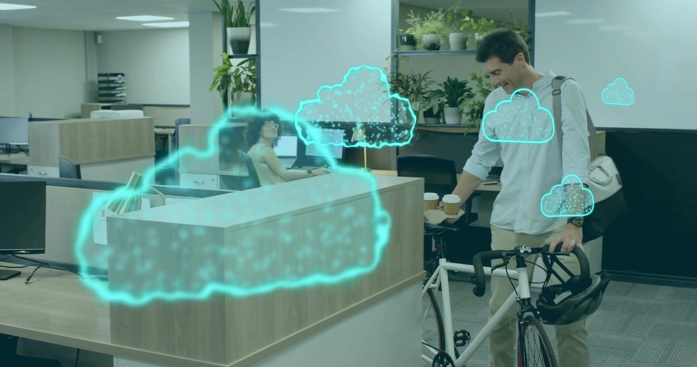 Holographic cloud appearing above office desk, woman typing as man enters handing coffee bonding