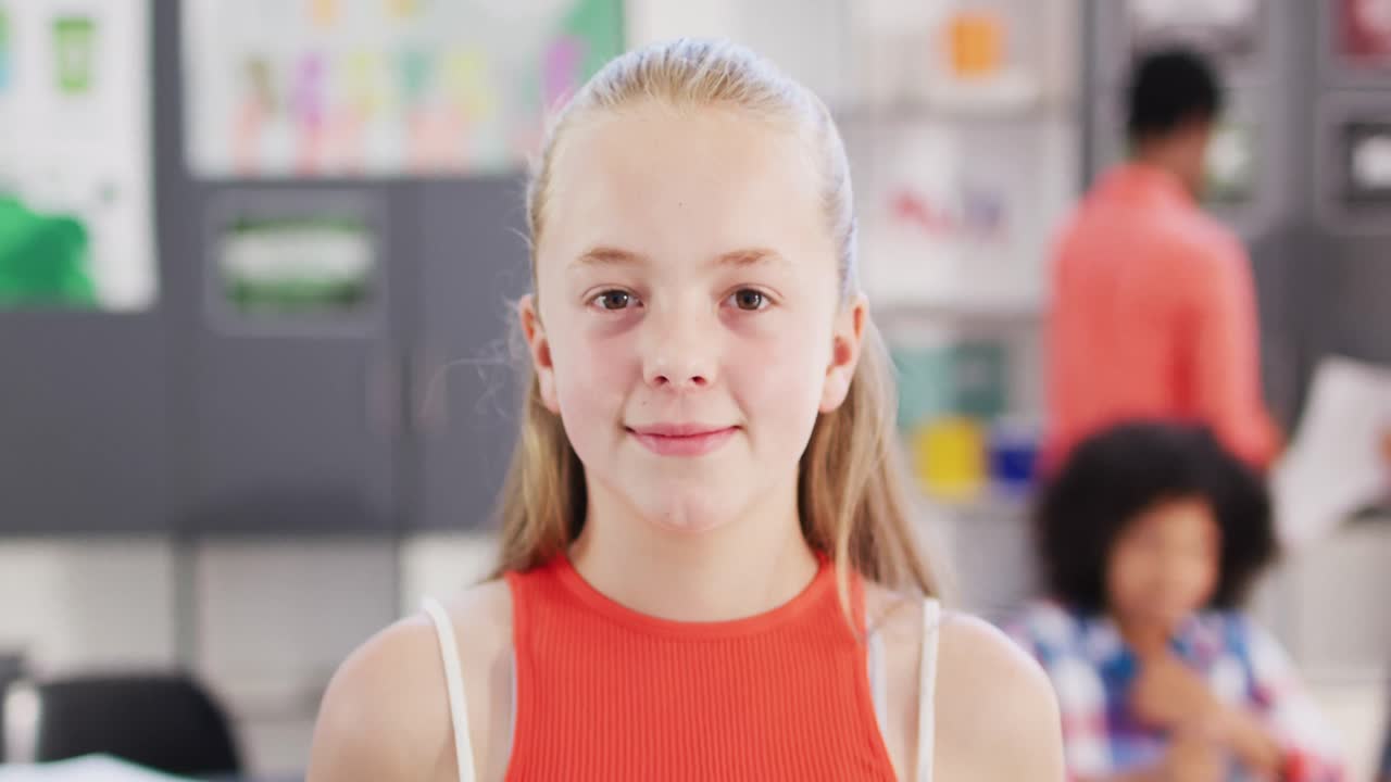 retrato de una estudiante caucásica feliz en un escritorio en el aula de la escuela