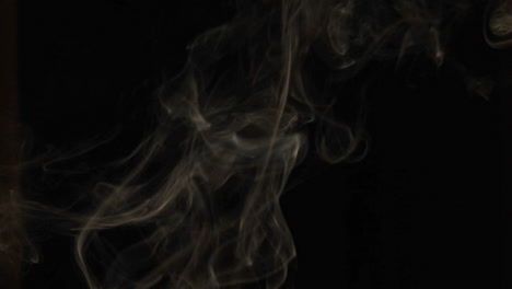 closeup of incense smoke rising against a black background