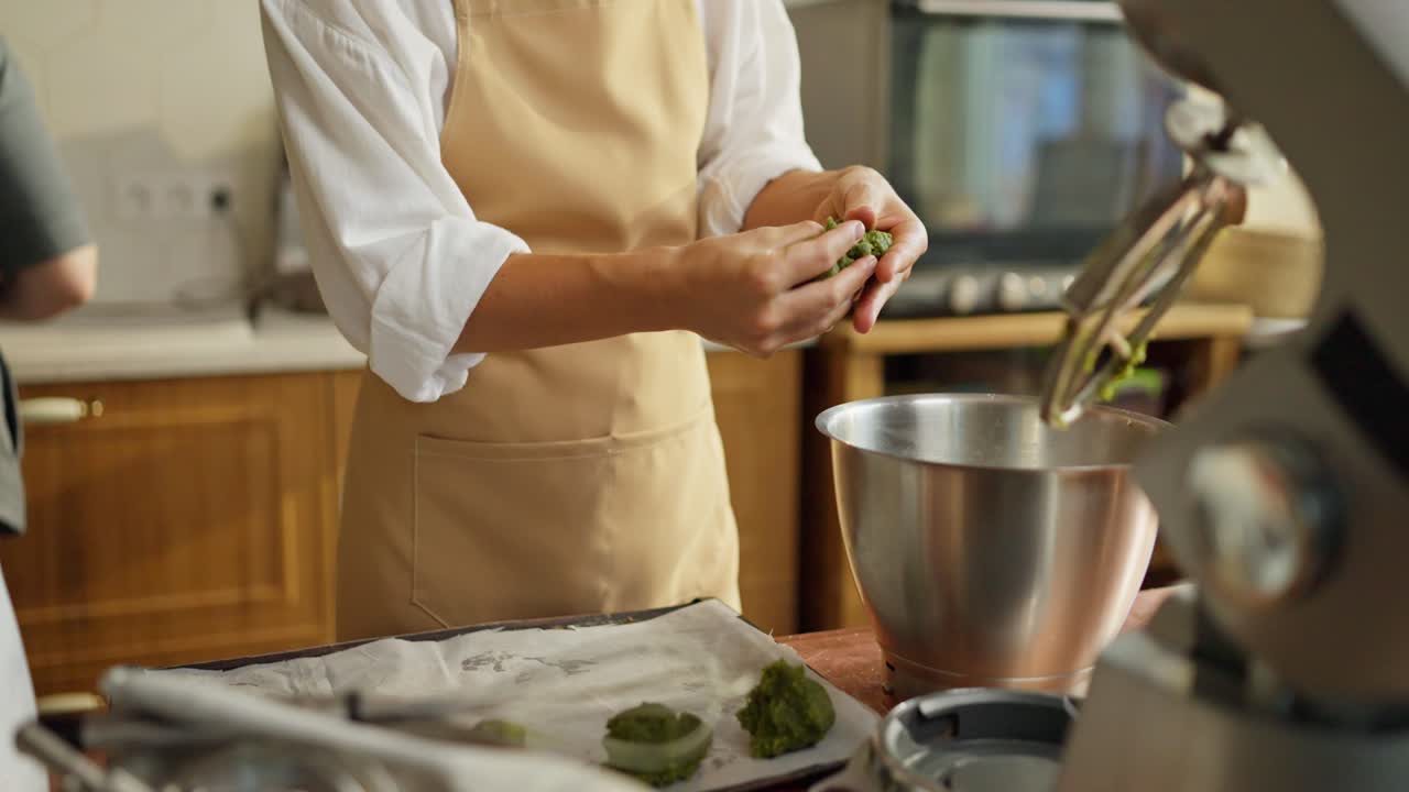 una mujer horneando galletas de matcha en la cocina.